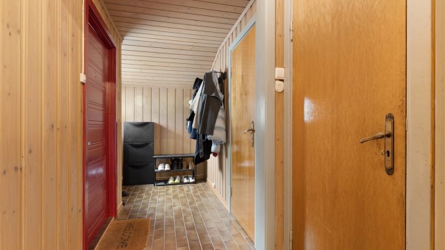 Entré med fliser på gulv og plass til oppbevaring av yttertøy.