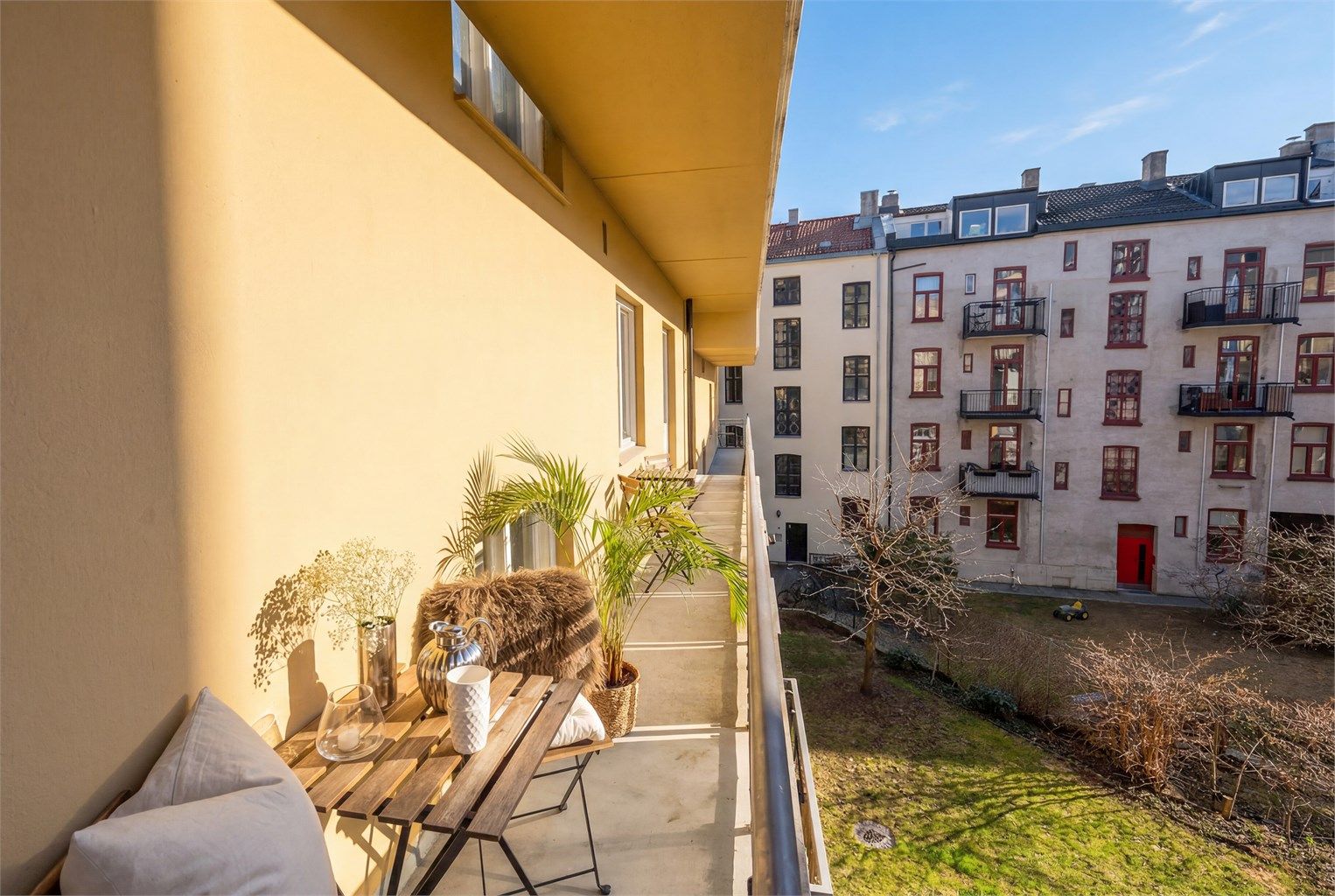 Brannbalkongen strekker seg langs leiligheten og gir et privat uterom, skjermet fra byens puls.