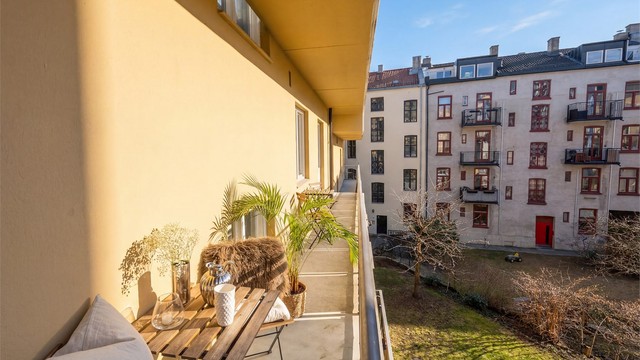 Brannbalkongen strekker seg langs leiligheten og gir et privat uterom, skjermet fra byens puls.