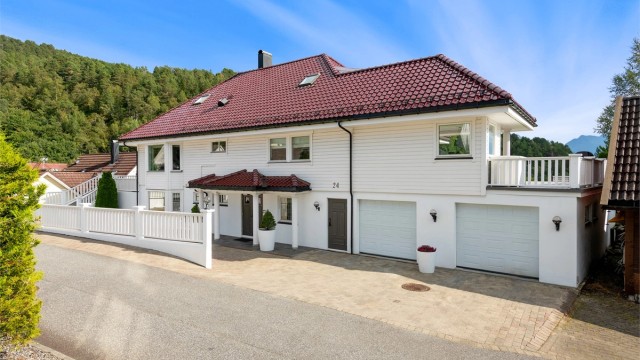 Fasade mot gate - 2 innskutt garasjeplasser i underetasjen