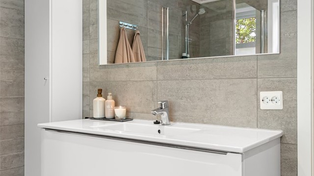Badet har vegghengt servantinnredning, speil med overlys og gulvvarme.