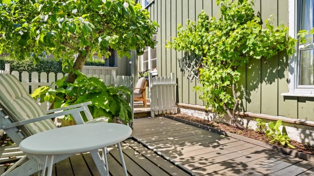 Sjarmerende detaljer som stakittgjerde og frukttrær.