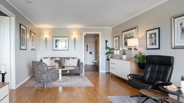 Stuen har god plass til sofagruppe og er utført med stående, malt mdf-panel på veggene.