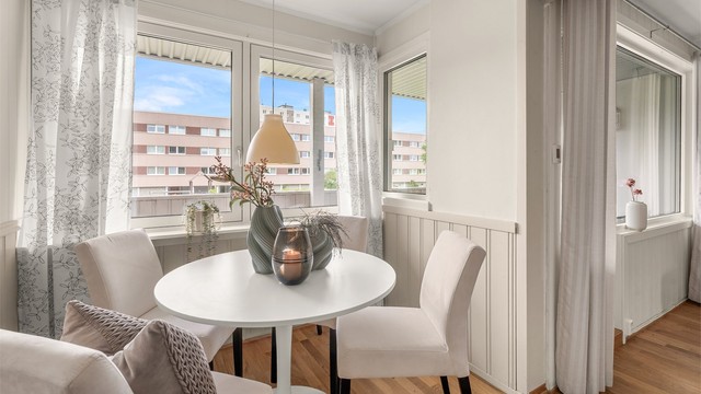 Romslig spiseplass i tilknytning til kjøkkenet, med gode vindusflater og åpen forbindelse mot stuen.