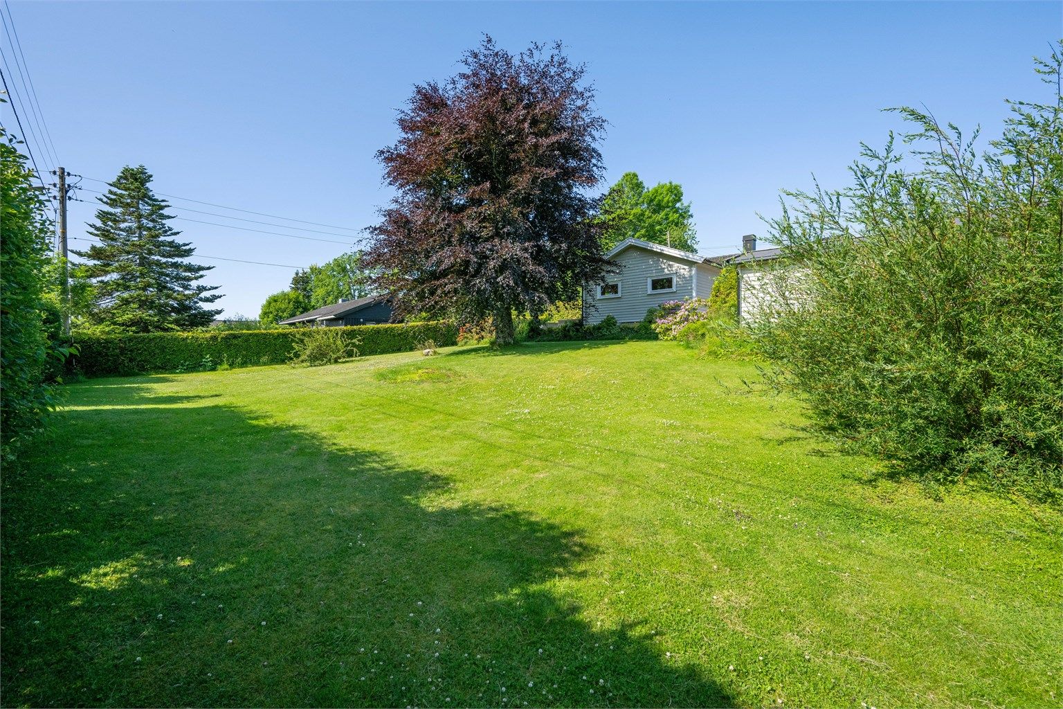 Huset er plassert slik at det er sammenhengende stor tomt (1 338 kvm) som er opparbeidet med gressplen/blomsterbed. 