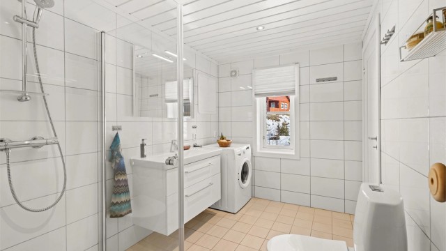 Pent, flislagt bad med gulvvarme og opplegg for vaskemaskin.