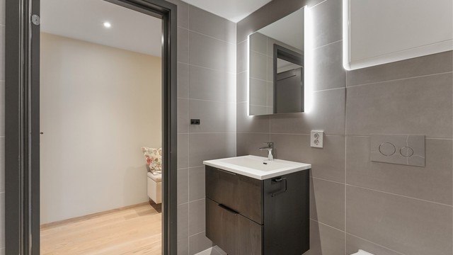 Badet har vannbåren gulvvarme, vegghengt toalett og dusjhjørne med innfellbare glassdører.