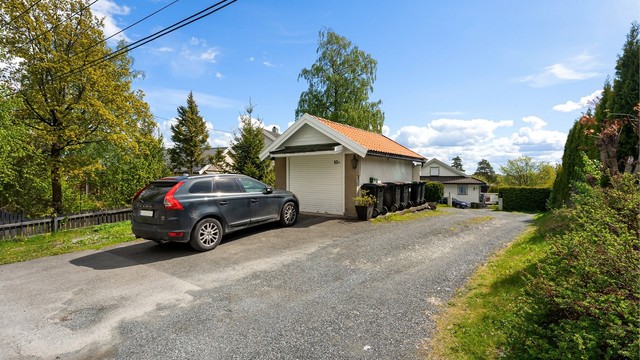 Eiendommen har en frittstående garasje og felles parkering med nabo.