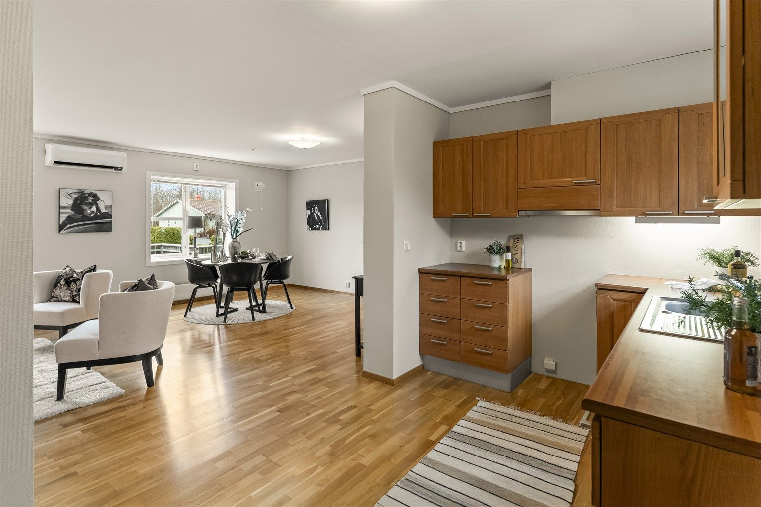 Den åpne løsningen mellom stue og kjøkken gir en sosial og luftig atmosfære, med gjennomlys i leiligheten.