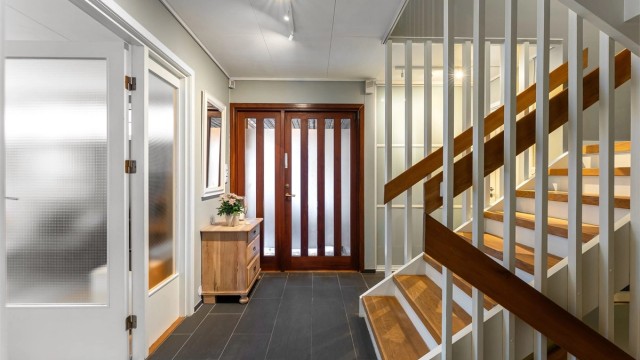 Innbydende hall med flislagt gulv og gulvvarme for økt komfort. Praktisk toalettrom rett ved inngang samt skyvedørs garderobe.
