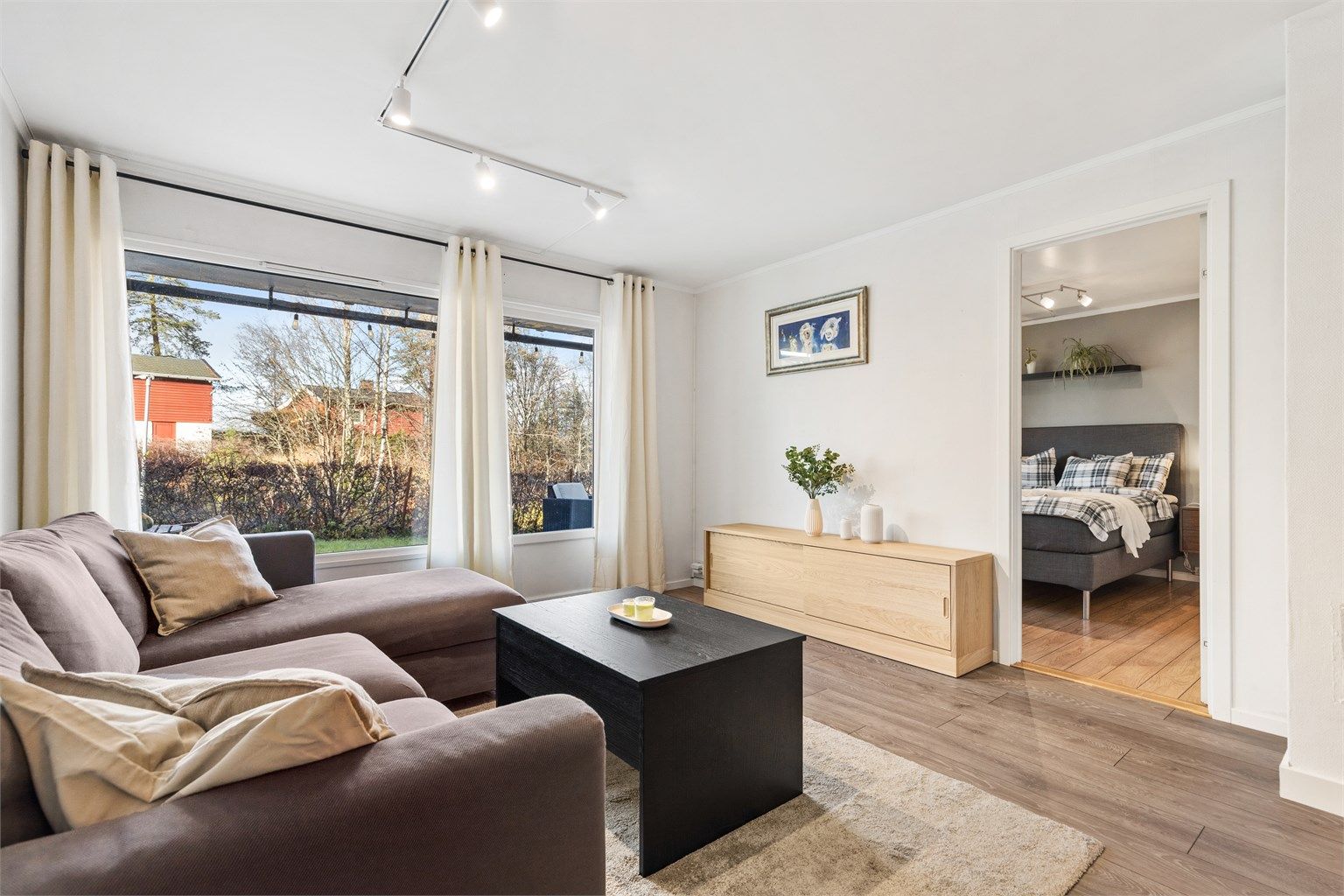 Lys og fin stue med plass til sittegruppe, TV-område og stort spisebord.