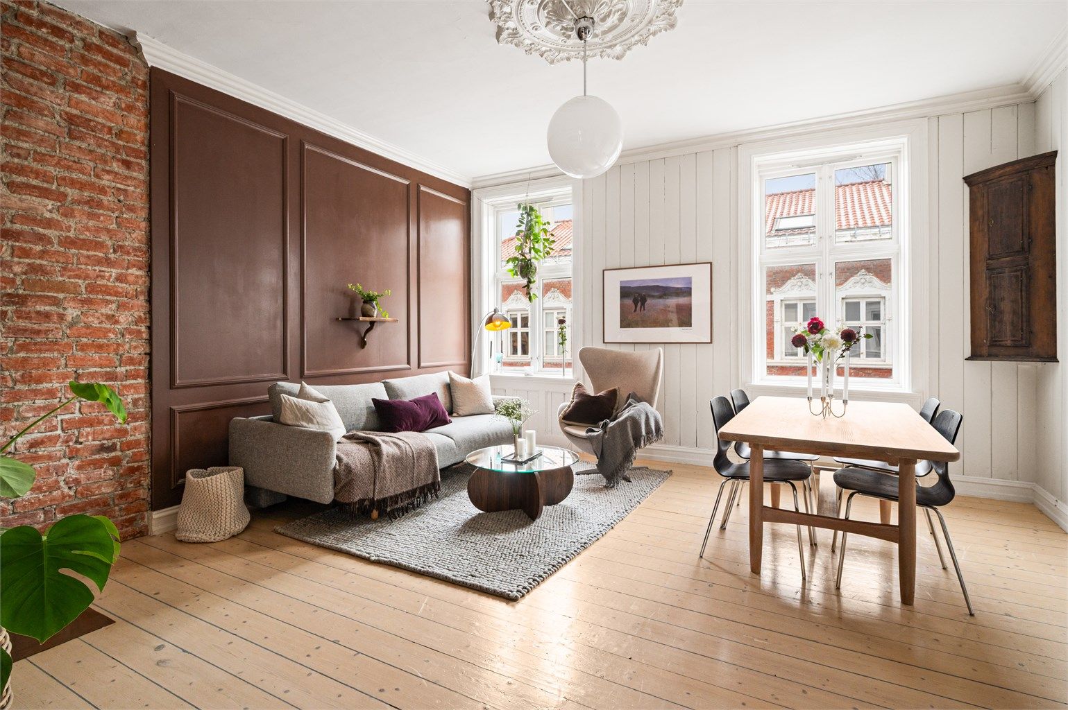 Stuen er romslig og gir god plass til både en større sofagruppe og en lesekrok. Klassiske detaljer og lune nyanser understreker leilighetens sjarm. 