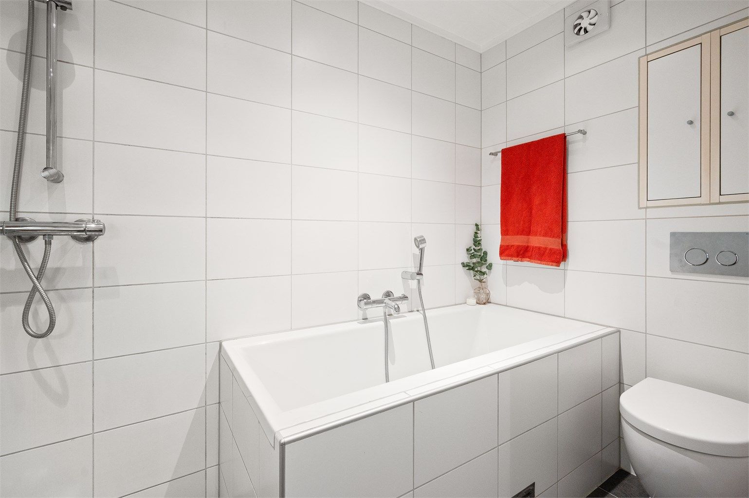 Badet fremstår lyst og delikat, og er praktisk innredet med både dusj og badekar.