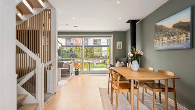 Stuen har god plass til både sofagruppe og spisebord, og peisovnen gir ekstra varme og hygge på kjøligere dager. (Foto: Petter Tanum/TanumFoto)