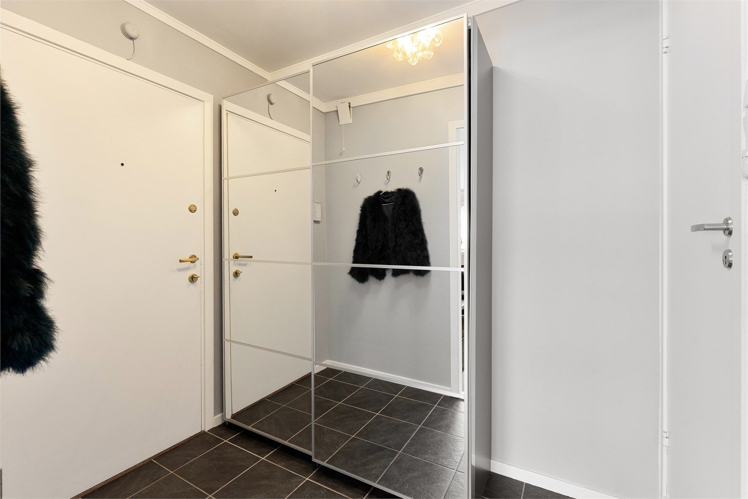 Entréen ønsker velkommen med god plass til yttertøy. Døren er brann- og lydklassifisert (B30/db35).