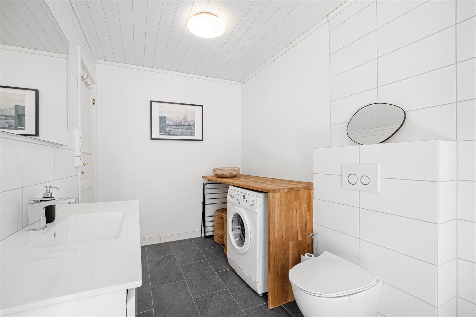 Det er en praktisk nisje med opplegg til vaskemaskin samt arbeidsbenk som passer ypperlig til klesbretting eller som stellebord. 