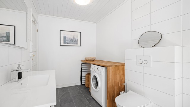Det er en praktisk nisje med opplegg til vaskemaskin samt arbeidsbenk som passer ypperlig til klesbretting eller som stellebord.