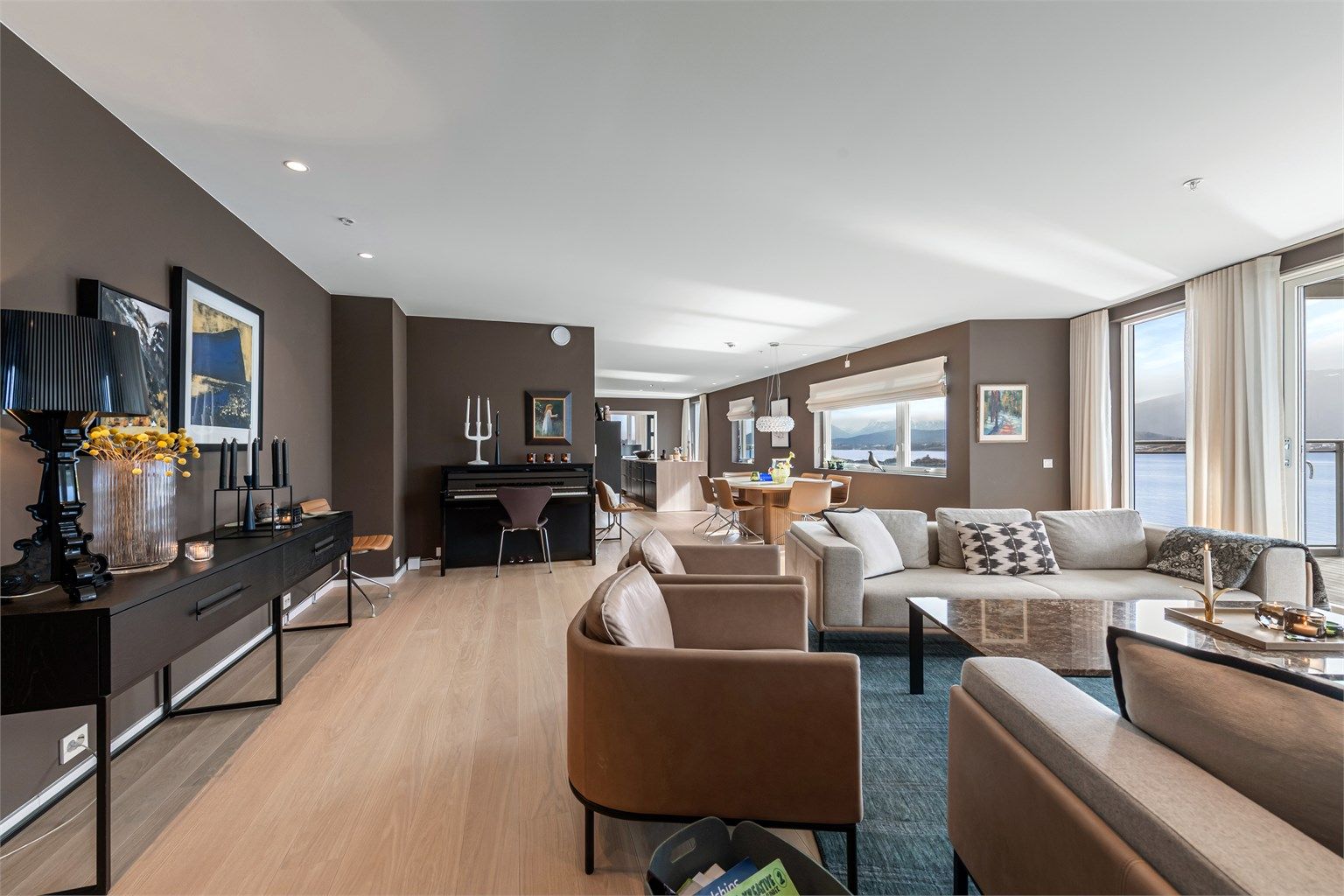 Stue og kjøkken i åpen løsning. Store vindusflater mot sjøsiden mot syd som gir flott utsikt og gode lysforhold