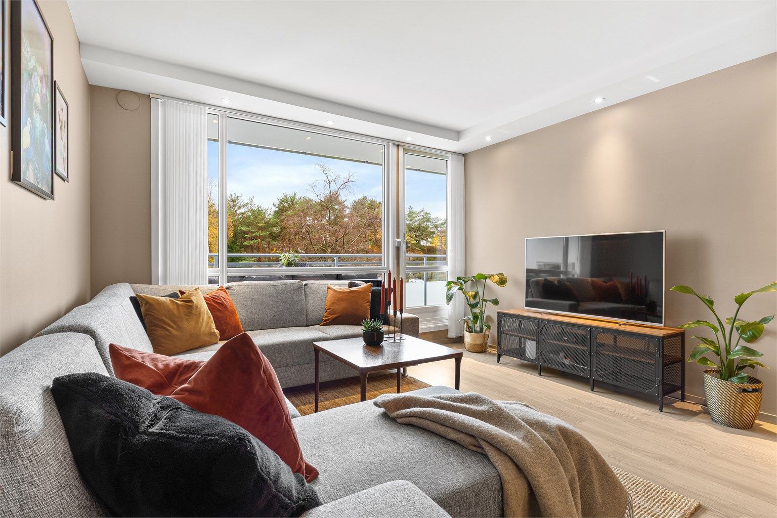 Stuen har lune farger, fin belysning og moderne en-stavs laminatgulv.