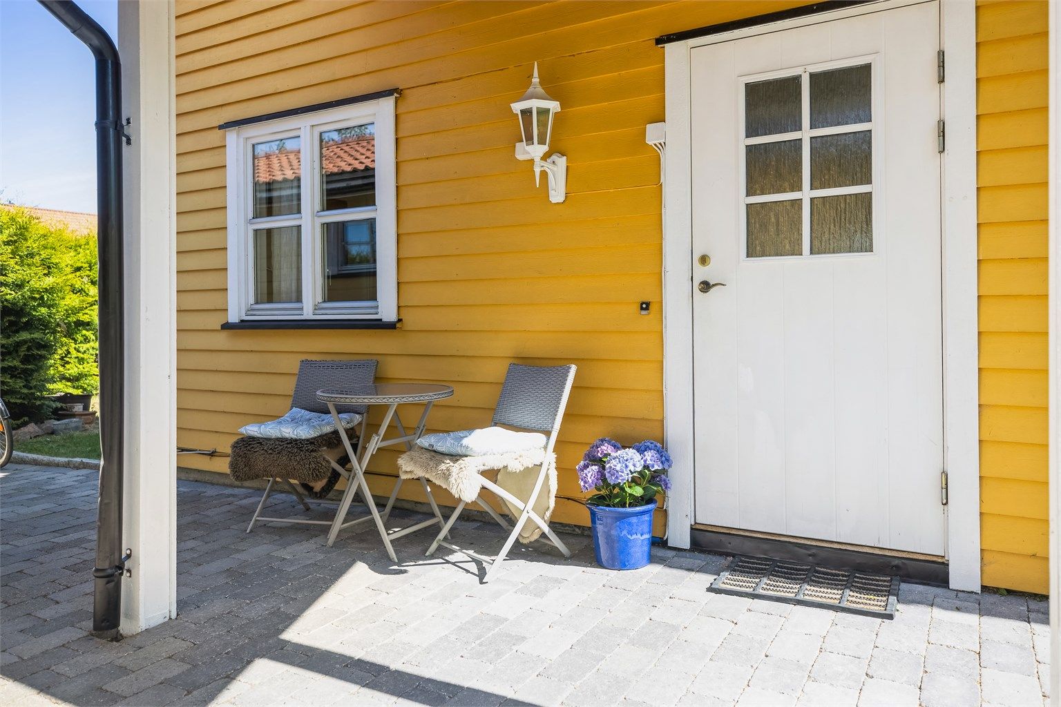 Overbygget inngangsparti med hyggelig sitteplass.