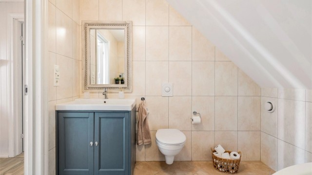 Badet i andre etasje har flislagt gulv med varme og vegghengt toalett.