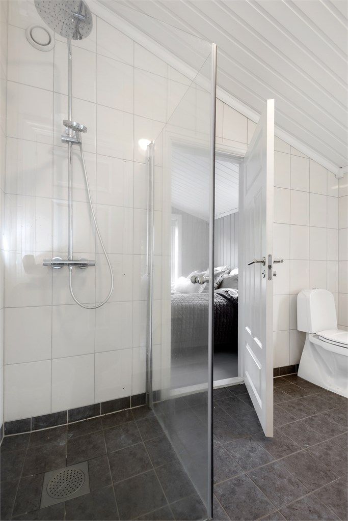 Badet har dusjnisje med glassvegg og trepanel i himling.