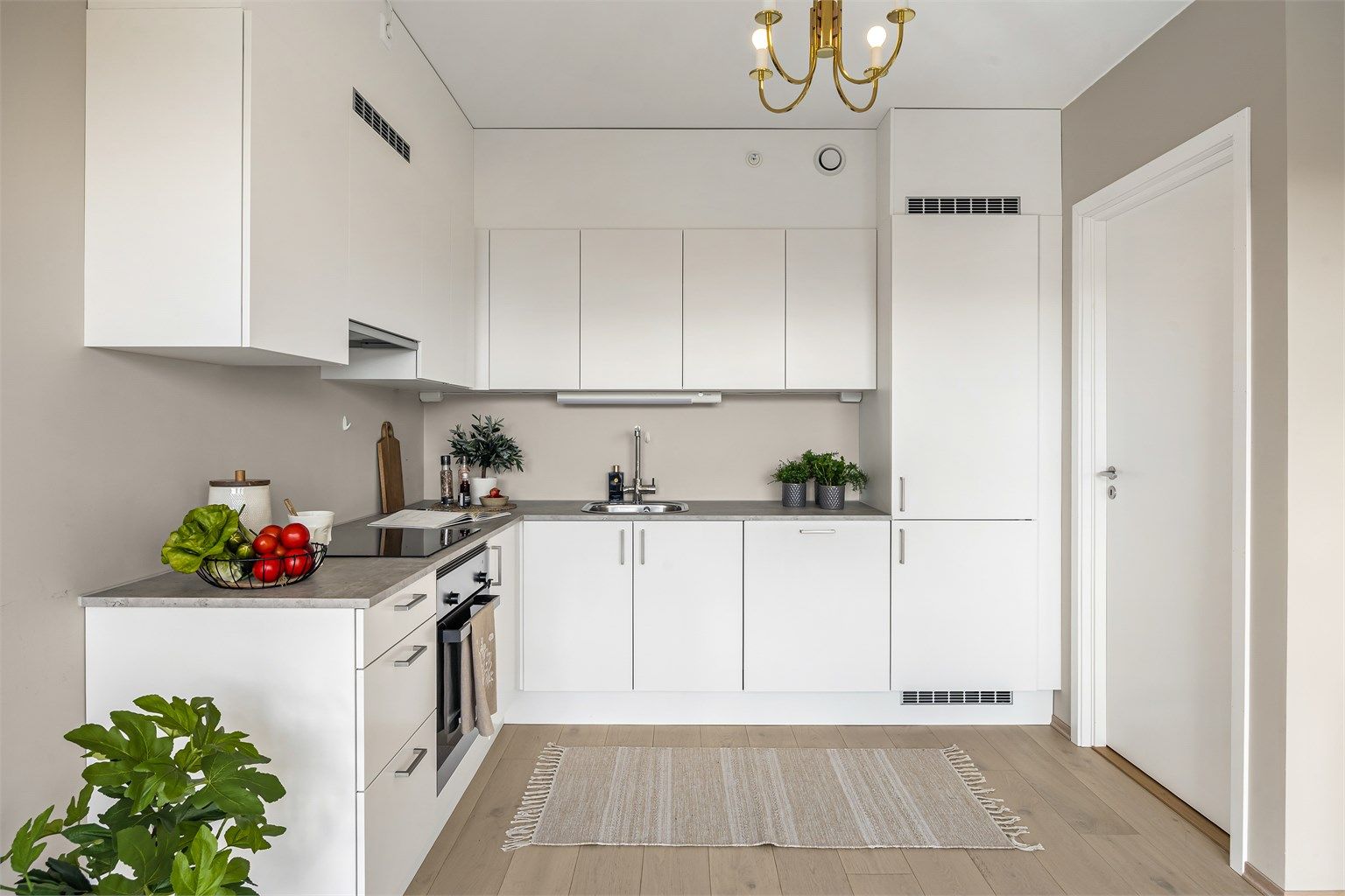 Kjøkkeninnredning med hvite og glatte fronter og benkeplate med laminert overflate