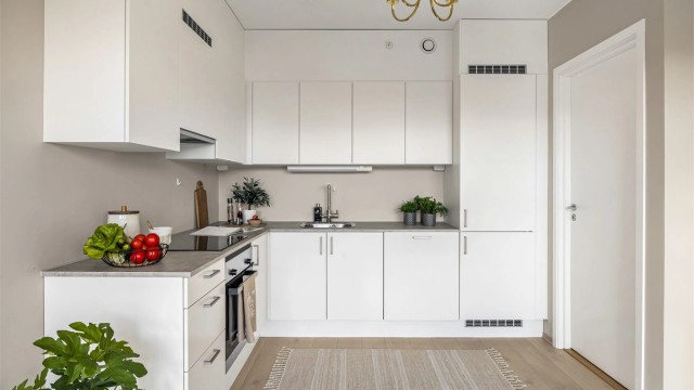 Kjøkkeninnredning med hvite og glatte fronter og benkeplate med laminert overflate