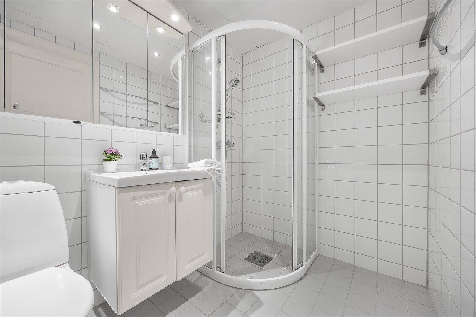 Hovedbadet har flislagte overflater, dusjhjørne og downlights i himling.