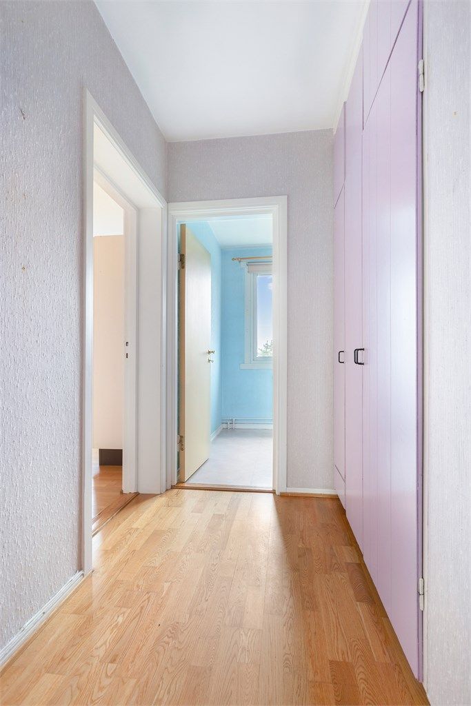 Man kommer inn i en entré med parkett på gulv og tapetserte vegger.