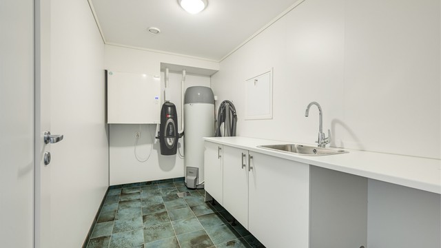 Separat vaskerom med egen inngang, flislagt gulv med varme og vaskeromsinnredning. Her er også boligens tekniske anlegg plassert.