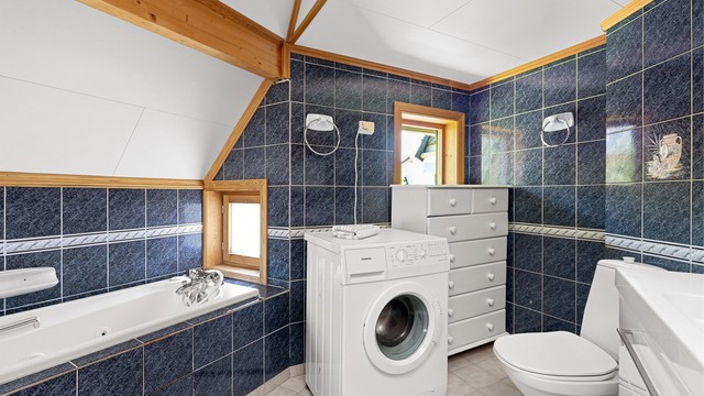 Badet har også et innfliset badekar og opplegg for vaskemaskin
