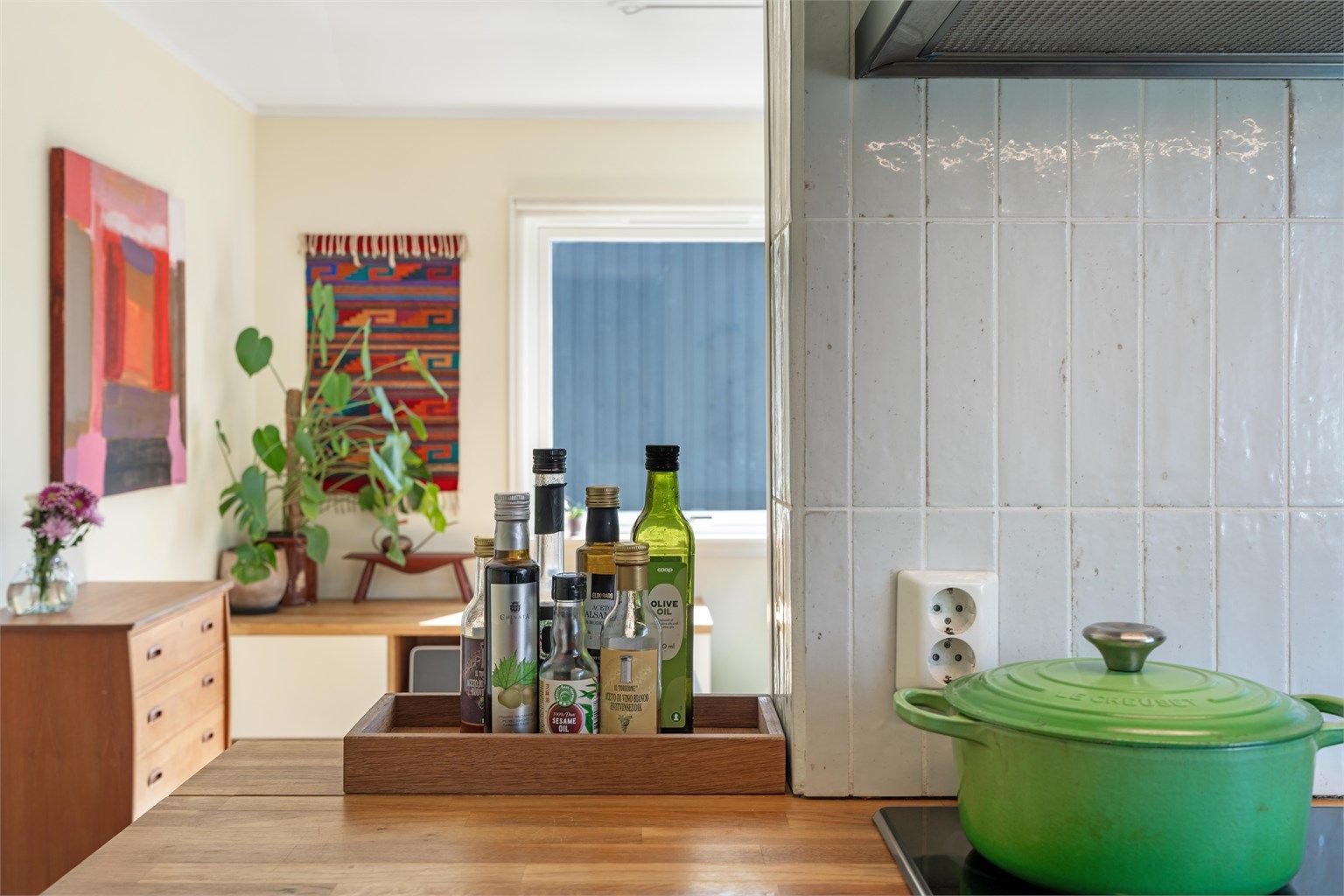 Fliser over arbeidsbenken beskytter veggen og komplementerer benkeplaten i tre.