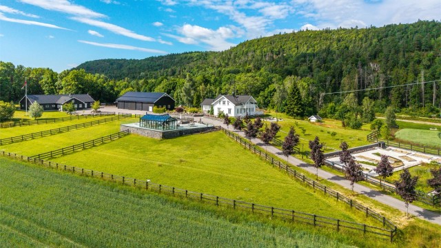 Eiendommen ligger idyllisk til, omkranset av egne jorder, med vakker utsikt over det åpne og bølgende landskapet.