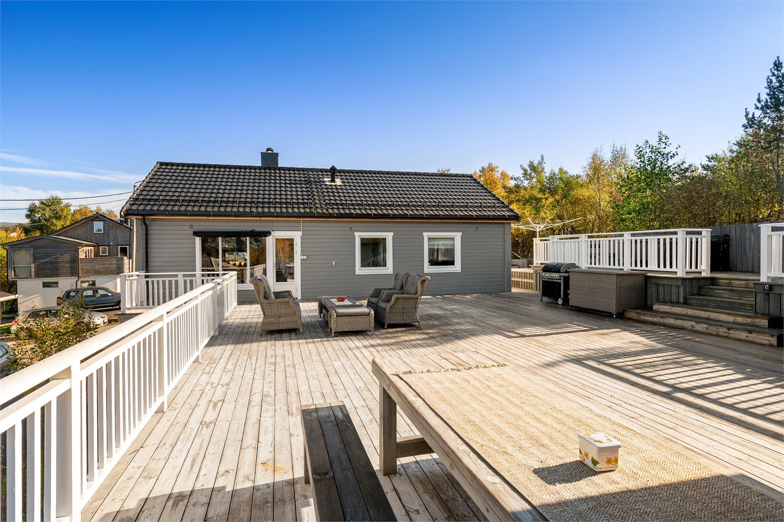 Terrasse i trekonstruksjoner med dekke av terrassebord ut fra stuen.