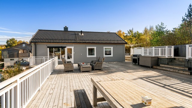 Terrasse i trekonstruksjoner med dekke av terrassebord ut fra stuen.