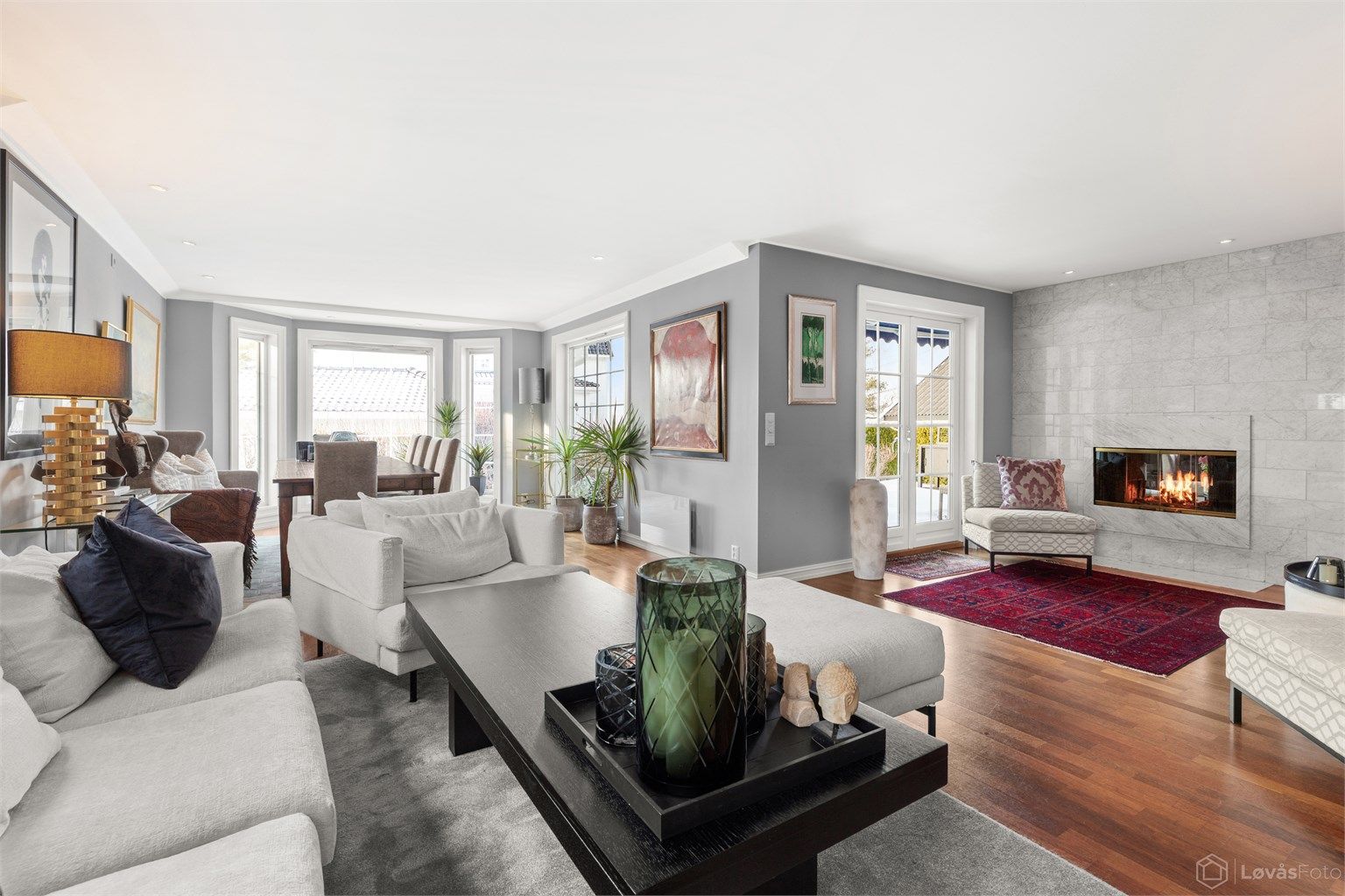 Stor kombinert stue og spisestue med store vindusflater som gir rommet rikelig med lys