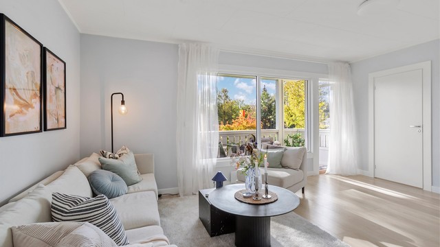 Stuen har store vindusflater og god plass til en romslig sofagruppe.
