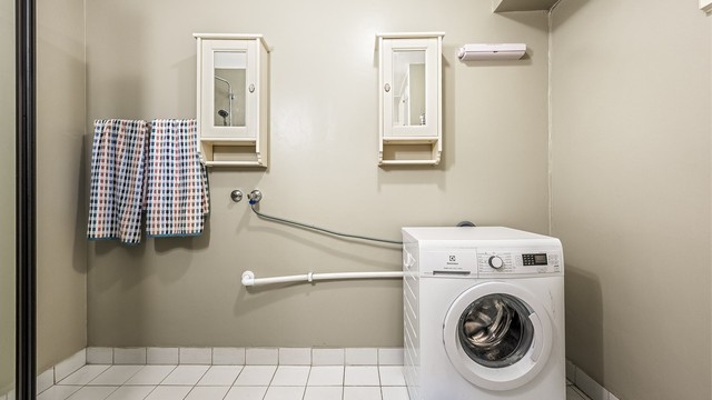 Badet har flislagt gulv og opplegg for vaskemaskin.