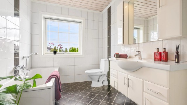 Badet er fra byggeår og har flislagt gulv med gulvvarme samt flislagte vegger. Himlingen er utført med panelbord