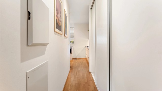 Gangen har skyvedørsgarderobe og gjennomgående parkettgulv.