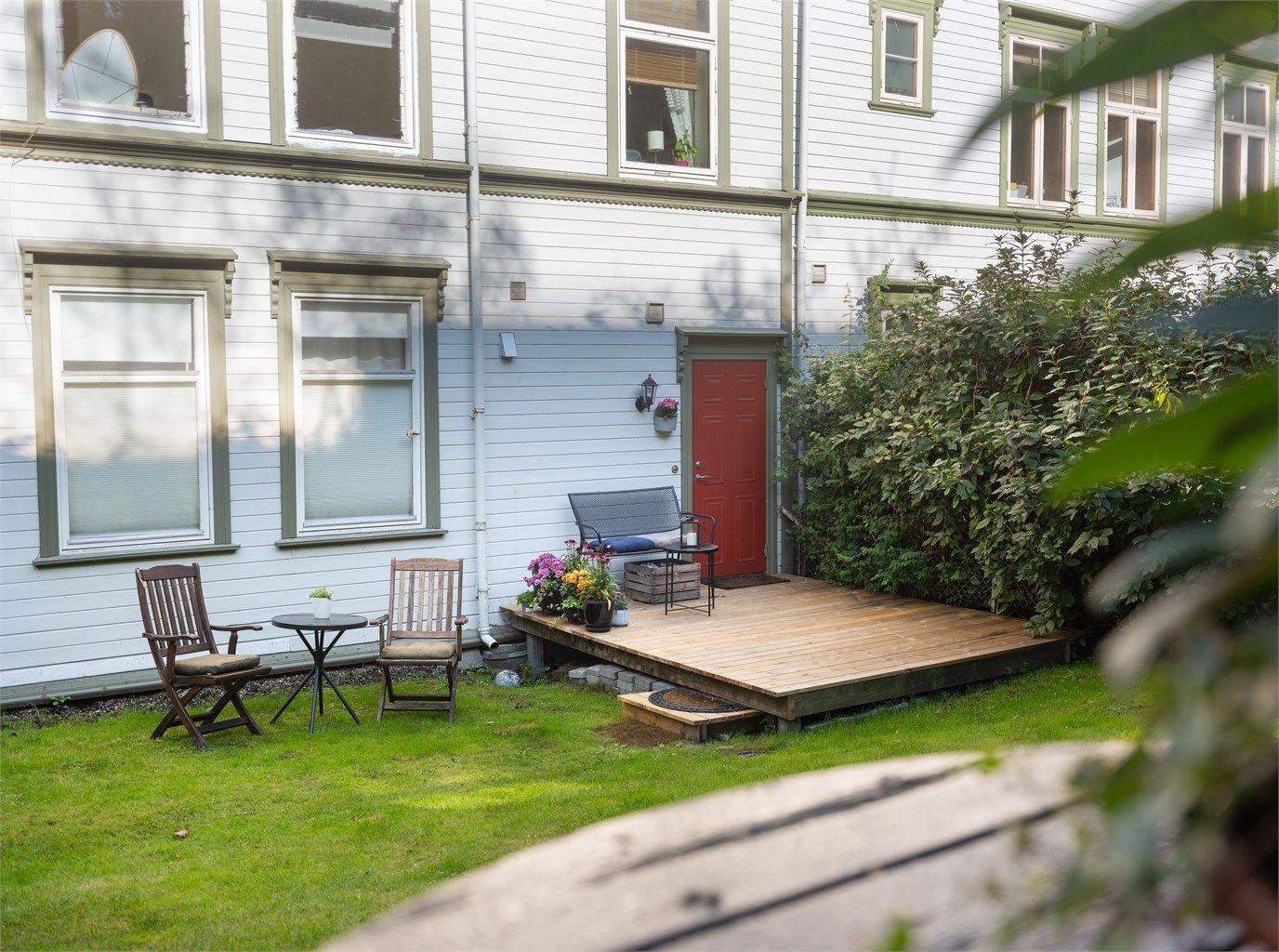 Hage, terrasse og inngang. Kjøkken i 2. etg over. 