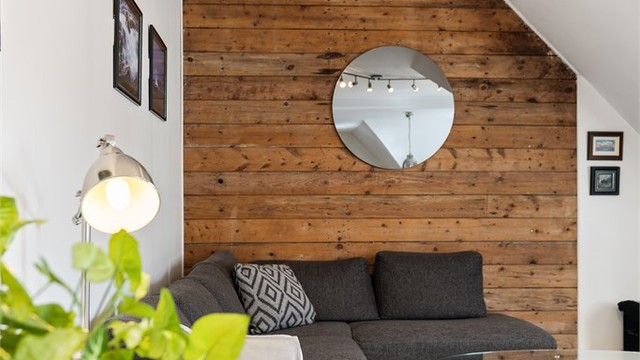 På stuen er det en særegen kontrastvegg med trepanel