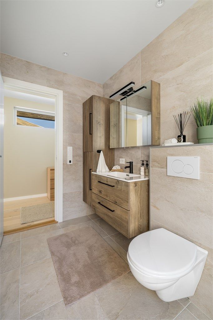 Her er det vegghengt toalett og varmekabler i de store 50x50 gulvflisene.