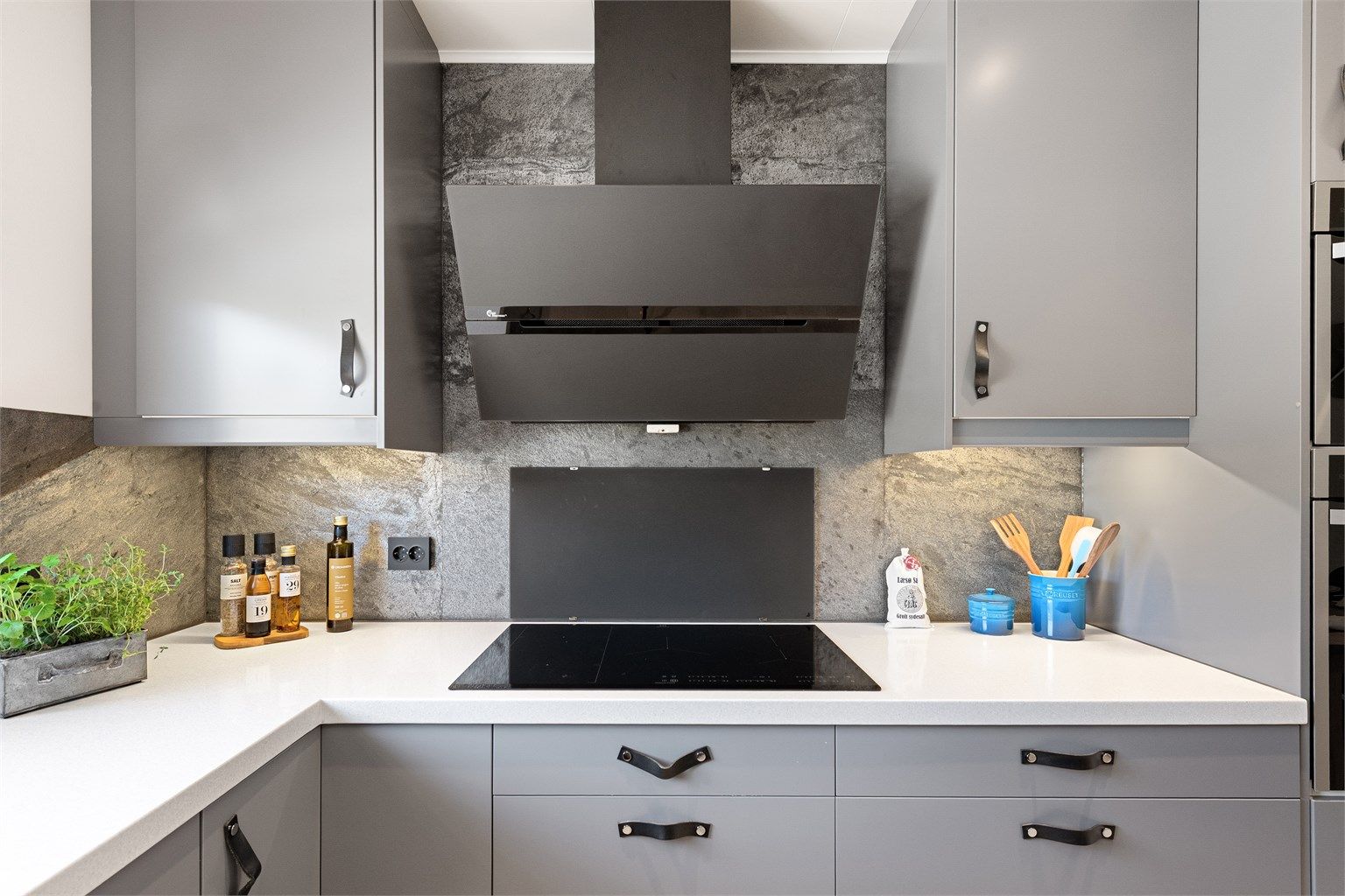 Induksjonstopp med komfyrvakt og en vegghengt ventilator. Automatisk vannstopper er installert for ekstra trygghet.