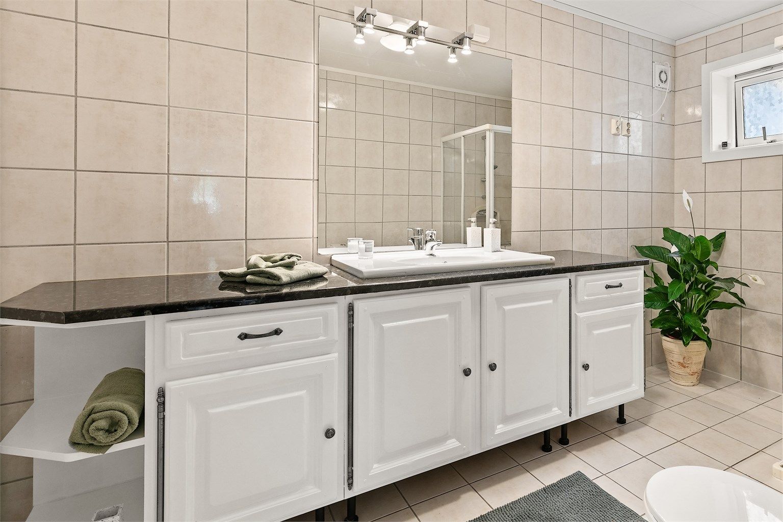 Bad med flislagt gulv og elektrisk gulvvarme og flislagte vegger.