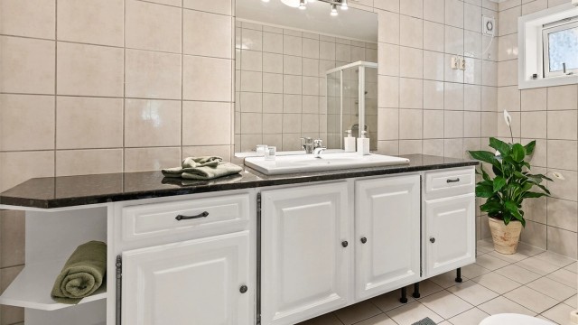 Bad med flislagt gulv og elektrisk gulvvarme og flislagte vegger.