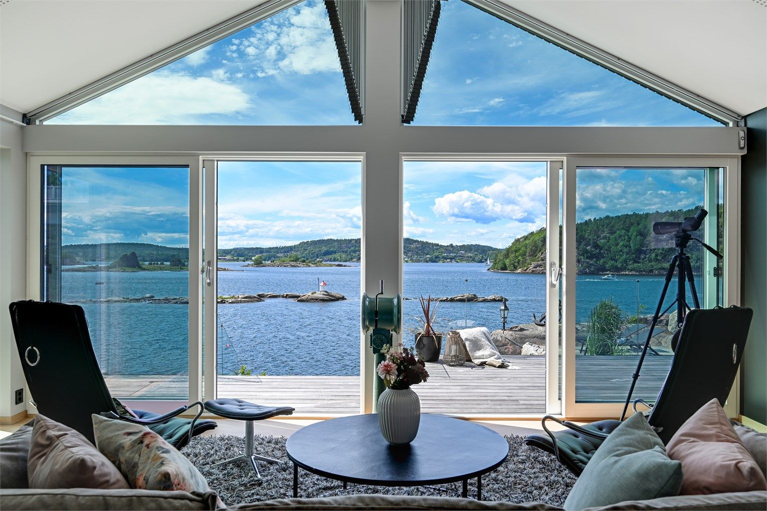 Det er adkomst ut til den flotte terrassen og hagen. Her får du sjøen rett inn i stuen. 
