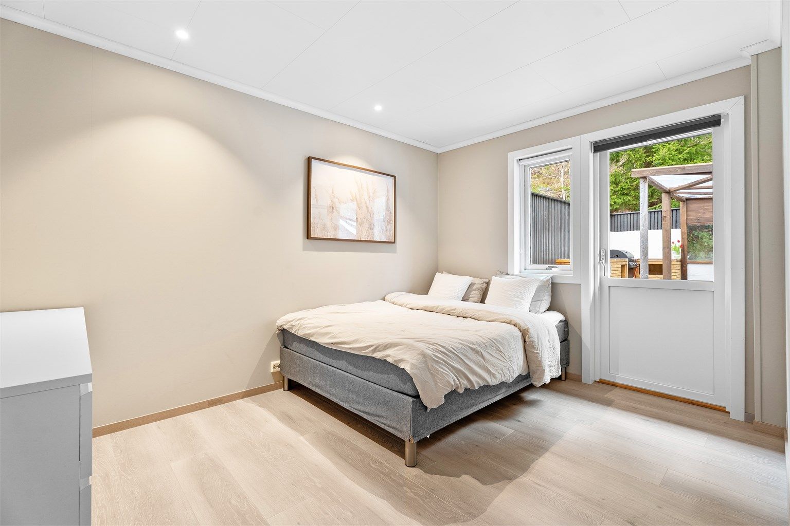 I samme etasje finner du ett av boligens tre soverom. Her er det god plass til dobbeltseng, garderobe og tilhørende møblement. 