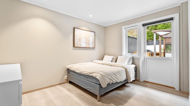 I samme etasje finner du ett av boligens tre soverom. Her er det god plass til dobbeltseng, garderobe og tilhørende møblement.